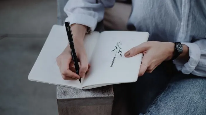 artist writing designs ideas on his notebook